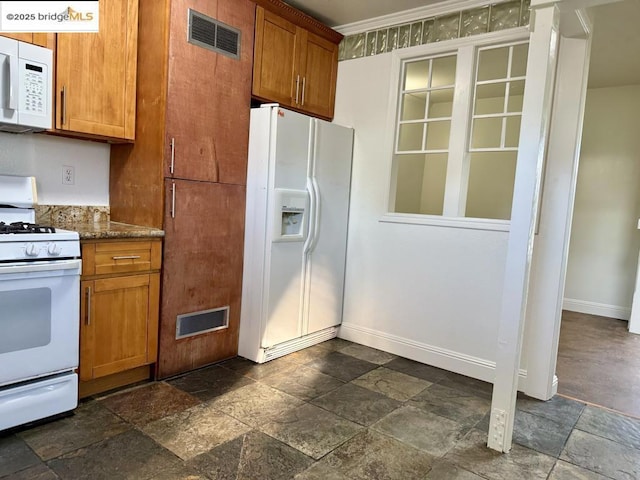 kitchen featuring white appliances and stone countertops