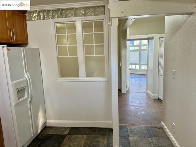 kitchen featuring white refrigerator with ice dispenser