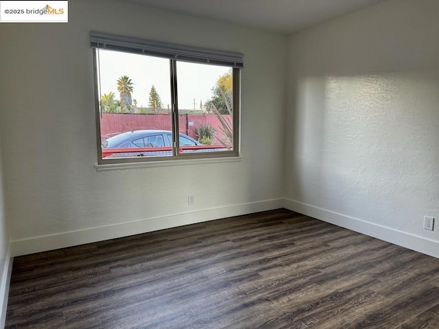 unfurnished room with dark hardwood / wood-style flooring