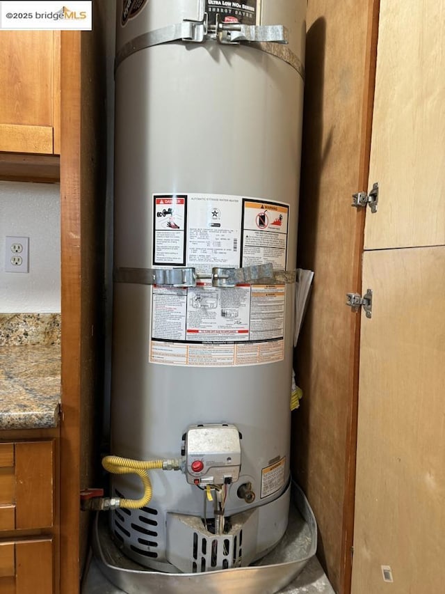 utility room featuring strapped water heater