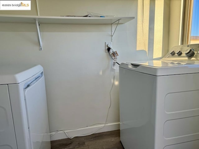 laundry area with independent washer and dryer and dark hardwood / wood-style flooring