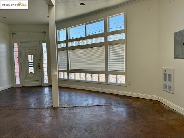 entryway with ornamental molding, heating unit, and electric panel