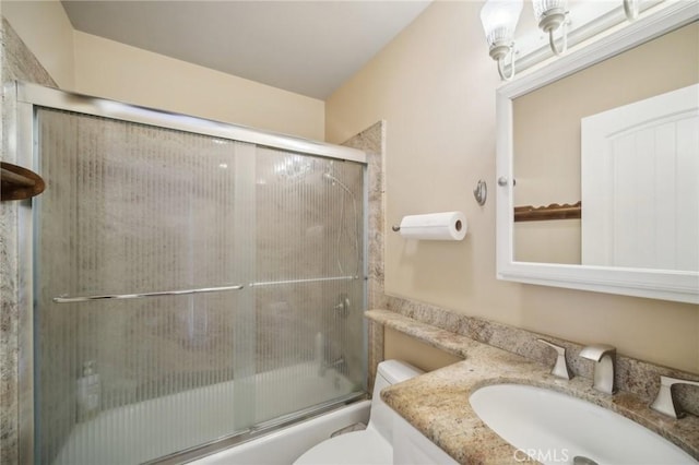 full bathroom featuring bath / shower combo with glass door, vanity, and toilet