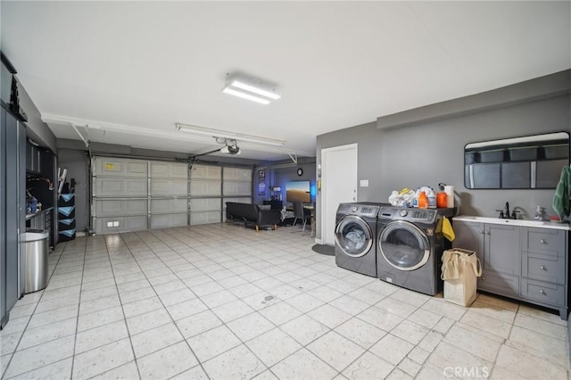 garage featuring a garage door opener, sink, and washing machine and dryer