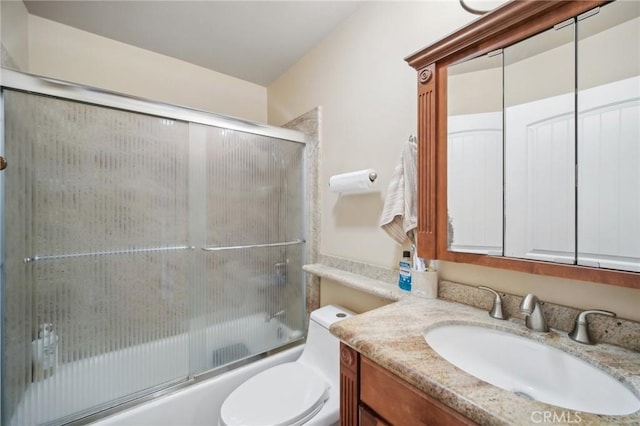 full bathroom with vanity, toilet, and combined bath / shower with glass door