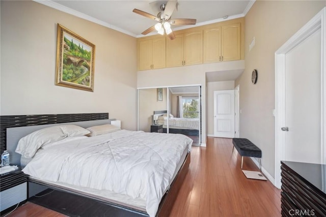 bedroom with crown molding, ceiling fan, a closet, and hardwood / wood-style flooring