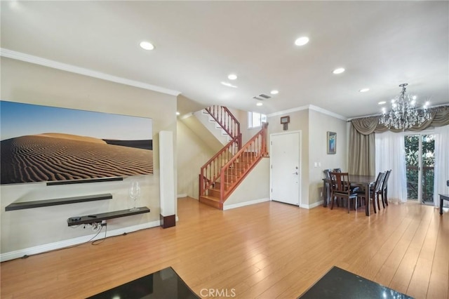 living room featuring an inviting chandelier, wood-type flooring, and ornamental molding