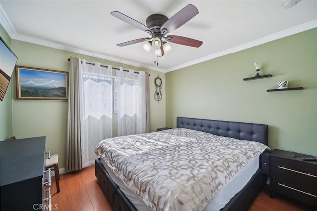 bedroom with crown molding, ceiling fan, and dark hardwood / wood-style floors