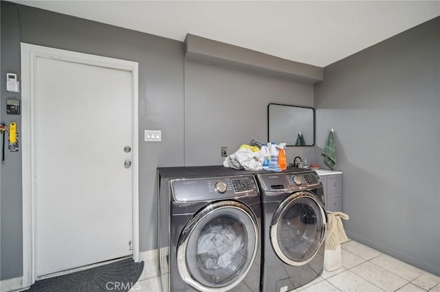 washroom featuring washing machine and dryer and light tile patterned floors