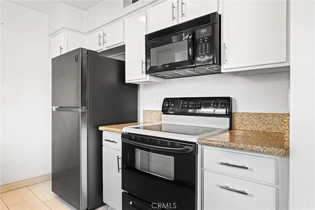 kitchen with range with electric cooktop, stainless steel fridge, light stone countertops, and white cabinets