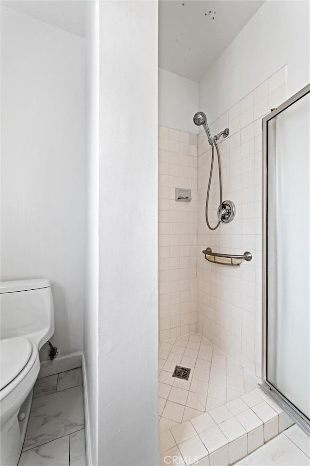 bathroom featuring a tile shower and toilet