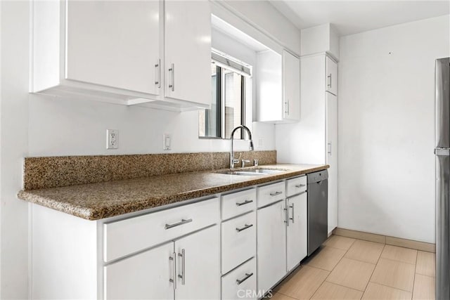 kitchen with dark stone countertops, appliances with stainless steel finishes, sink, and white cabinets