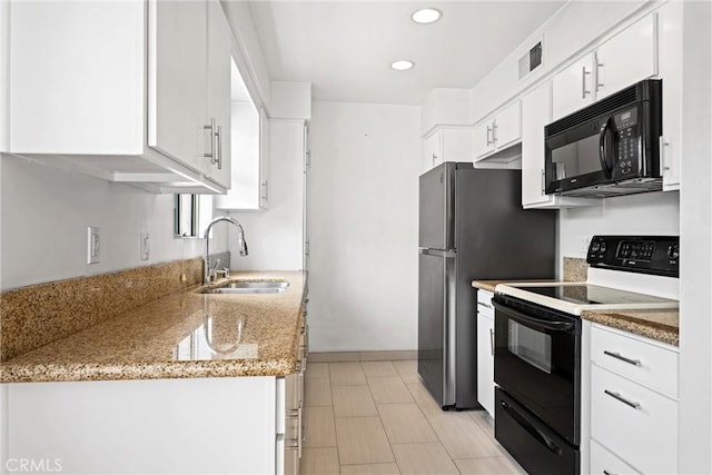 kitchen featuring electric stove, sink, light stone counters, and white cabinets