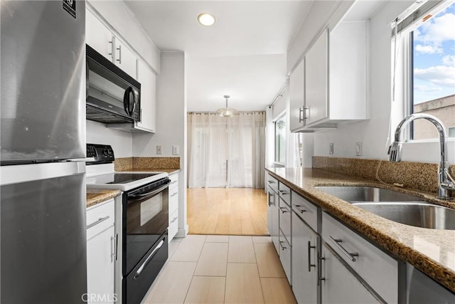 kitchen with sink, dark stone countertops, white cabinets, and black appliances