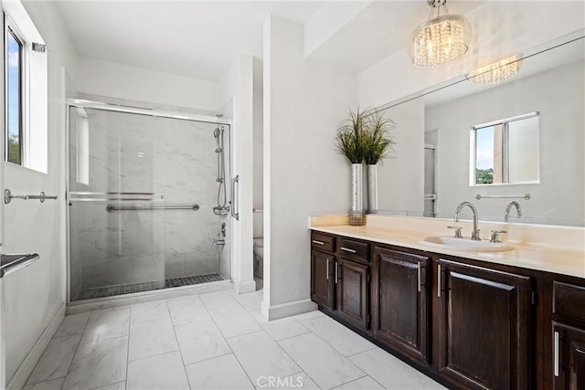 bathroom with vanity, a shower with door, and toilet