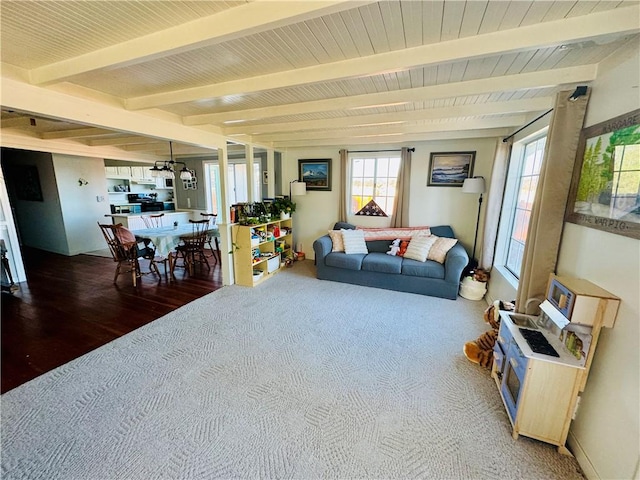 living room with beam ceiling and carpet flooring