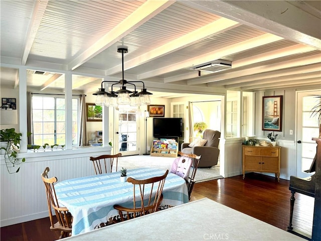 dining room featuring beam ceiling, dark wood-type flooring, and a chandelier