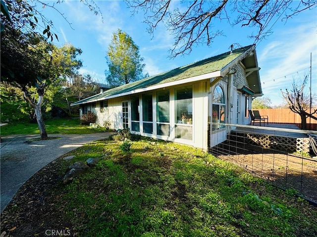 view of side of property with a yard and a deck