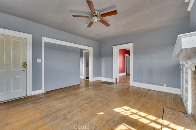 unfurnished living room with ceiling fan, a fireplace, and light hardwood / wood-style flooring