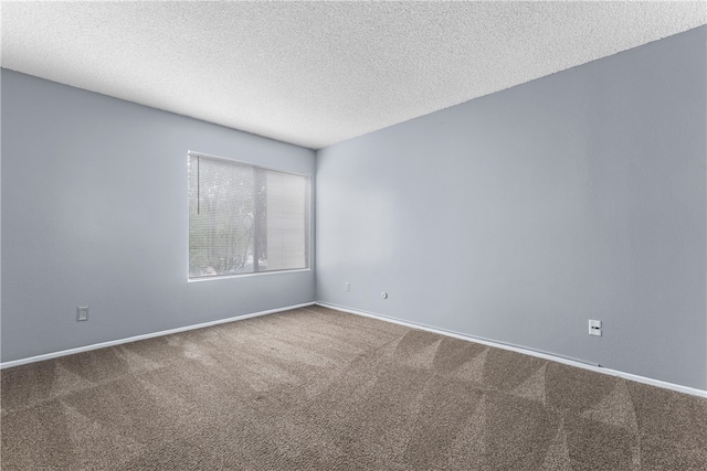 carpeted empty room featuring a textured ceiling