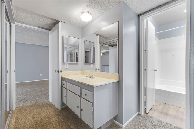 bathroom featuring vanity, shower / bathtub combination, and a textured ceiling