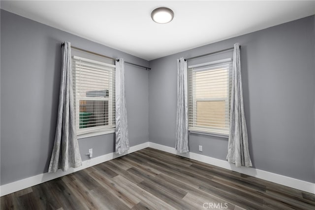 empty room with dark hardwood / wood-style flooring