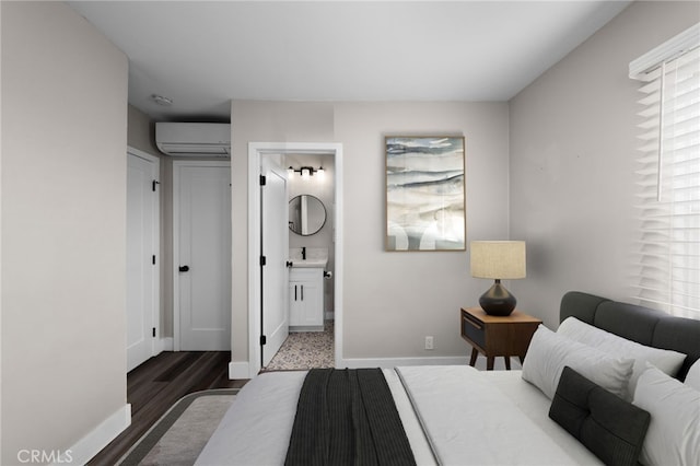 bedroom with hardwood / wood-style floors, sink, a wall mounted AC, and ensuite bath