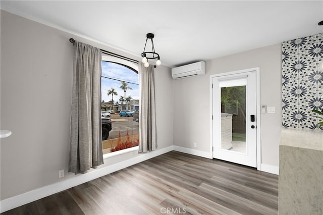 unfurnished dining area featuring a wall mounted air conditioner and wood-type flooring