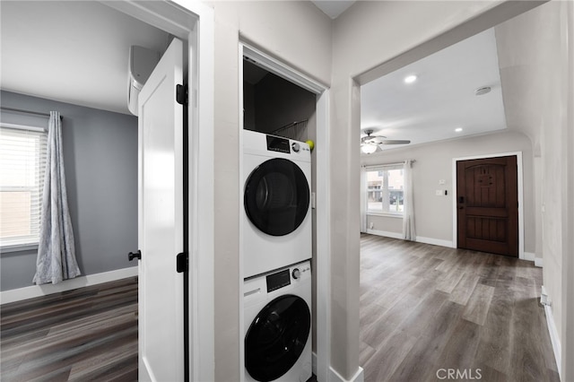 washroom featuring stacked washer and dryer, wood-type flooring, and ceiling fan