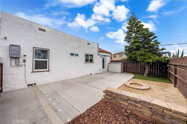 rear view of property with a patio and an outdoor fire pit