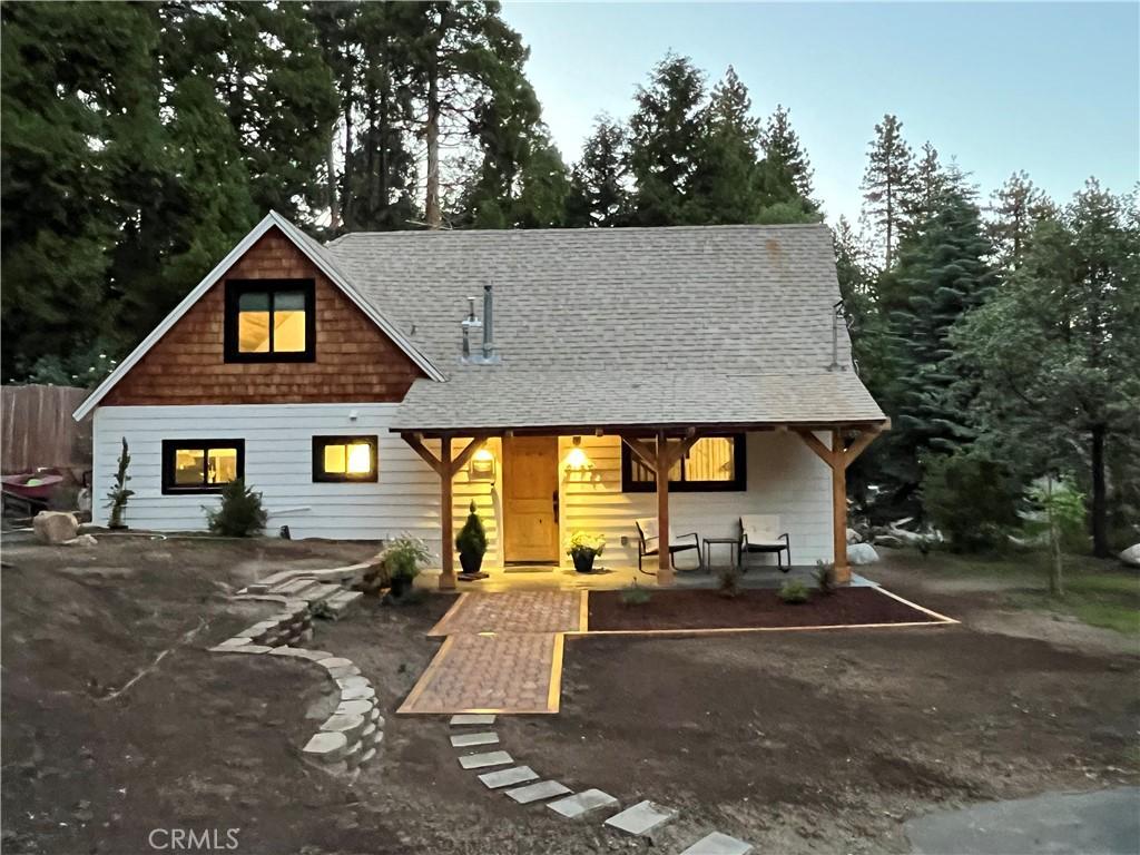 view of front of house with roof with shingles and a patio