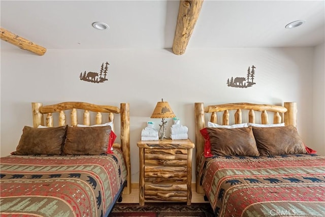 bedroom featuring beam ceiling and carpet flooring