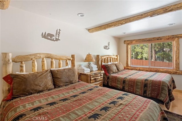 bedroom with beam ceiling and wood-type flooring