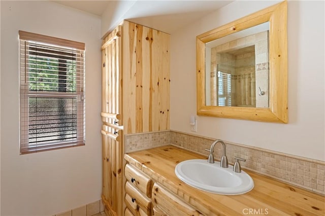 bathroom featuring vanity and tasteful backsplash