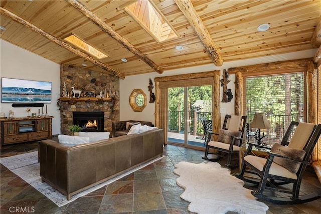 living room featuring wood ceiling, vaulted ceiling with skylight, and a stone fireplace