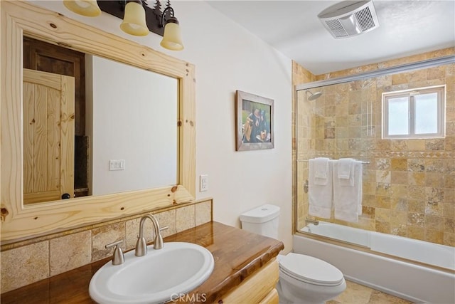 full bathroom with vanity, enclosed tub / shower combo, and toilet