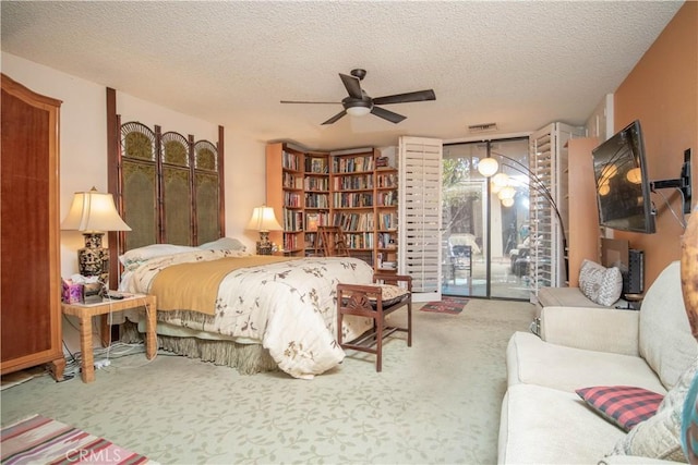 bedroom with ceiling fan, a textured ceiling, carpet, and access to outside