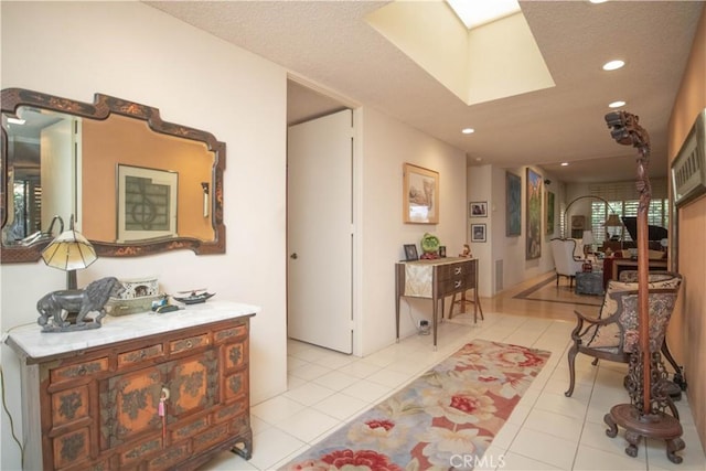 corridor featuring light tile patterned flooring and a skylight