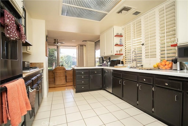 kitchen featuring light tile patterned floors, stainless steel appliances, white cabinets, and ceiling fan