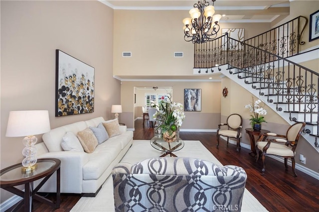 living room featuring a high ceiling, ornamental molding, dark hardwood / wood-style floors, and a notable chandelier