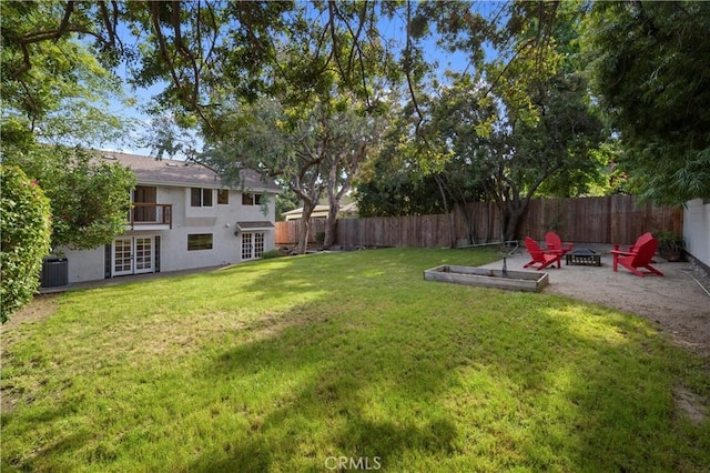 view of yard with french doors, central AC unit, and a fire pit