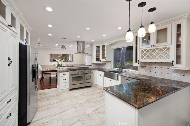 kitchen with sink, island range hood, hanging light fixtures, appliances with stainless steel finishes, and kitchen peninsula