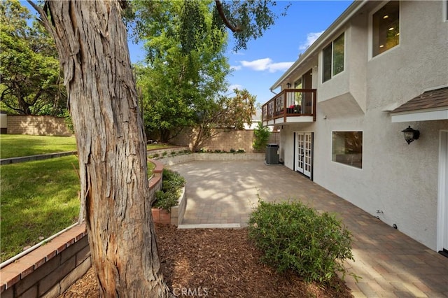 exterior space featuring french doors, a balcony, a patio, and central air condition unit