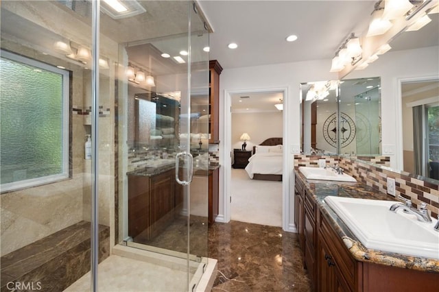 bathroom with a shower with door, vanity, and decorative backsplash