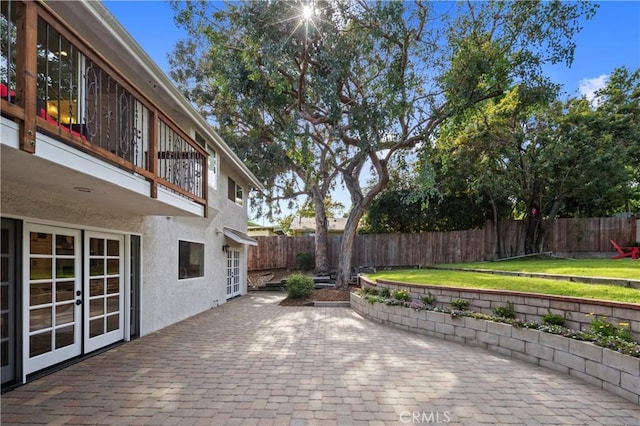 deck with a patio area, french doors, and a lawn