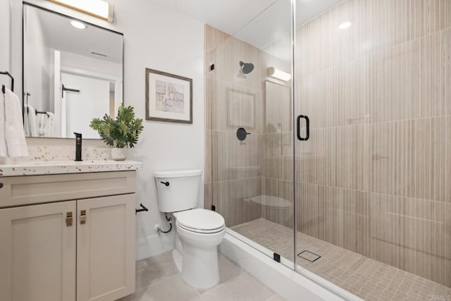 bathroom featuring vanity, toilet, tile patterned floors, and a shower with shower door