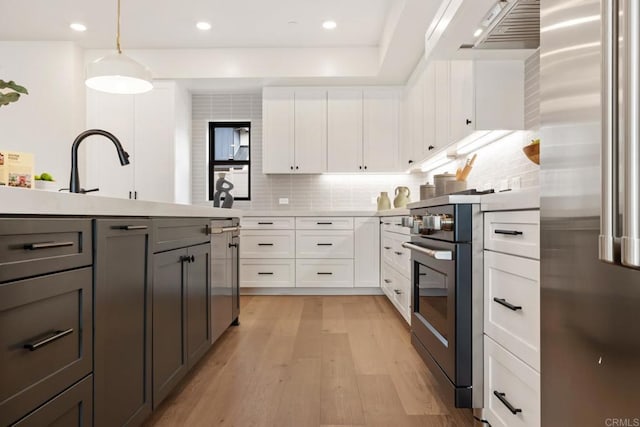 kitchen featuring hanging light fixtures, high end refrigerator, white cabinets, and backsplash