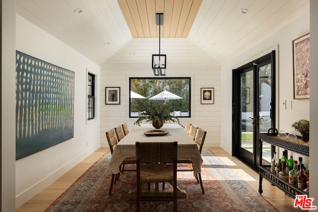 dining area featuring vaulted ceiling, wooden ceiling, and light wood-type flooring