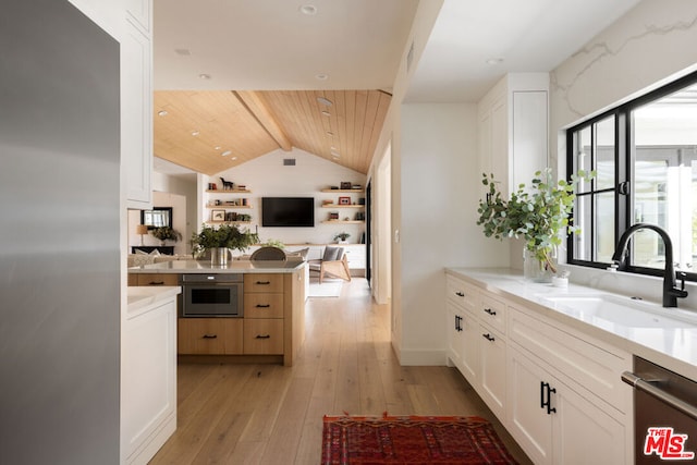 kitchen featuring white cabinetry, sink, light hardwood / wood-style floors, kitchen peninsula, and stainless steel appliances