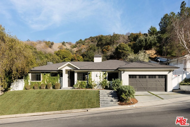 ranch-style home with a garage and a front yard